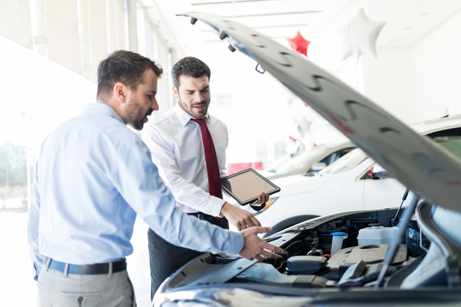 Dealer And Customer Discussing Over Car Engine